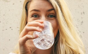 בחורה שותה כוס מים (צילום: unsplash)