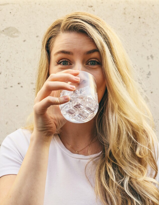 בחורה שותה כוס מים (צילום: unsplash)
