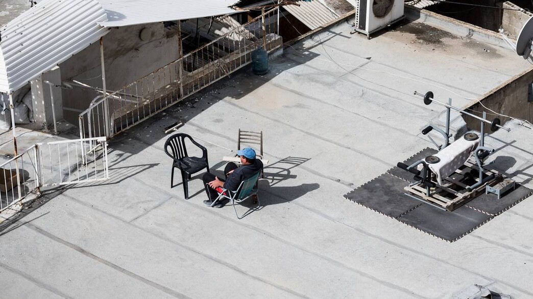 אדם יושב על גג בית (צילום:  Daniel Lerman, unsplash)