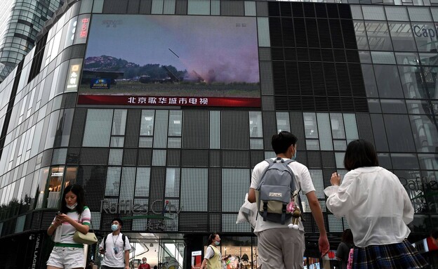 אנשים צופים בתרגיל הצבאי של סין נגד טייוואן (צילום: NOEL CELIS/AFP via Getty Images)