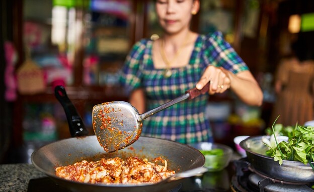 אישה תאילנדית מבשלת קארי עוף (צילום: Joshua Resnick, shutterstock)