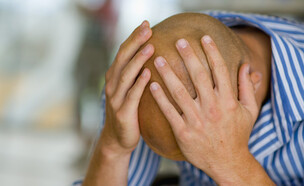 אדם קירח מחזיק את הראש (צילום: jupiter images)