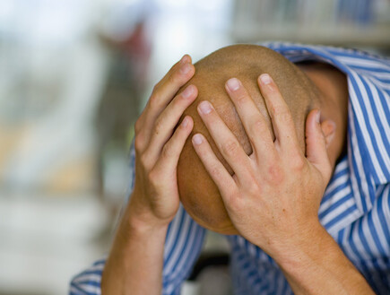 אדם קירח מחזיק את הראש (צילום: jupiter images)