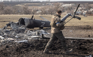 חייל על רקע שרידי מסוק שהופל (צילום: Chris McGrath/Getty Images)