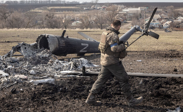 חייל על רקע שרידי מסוק שהופל (צילום: Chris McGrath/Getty Images)