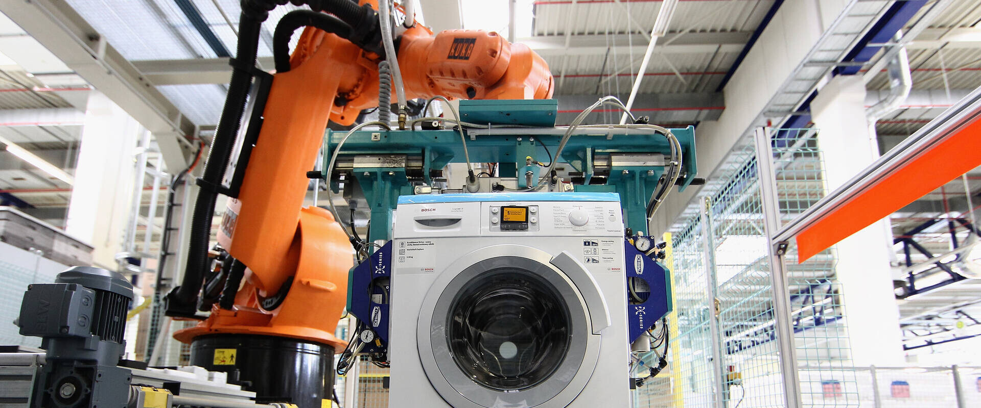 רובוט מרכיב מכונת כביסה במפעל BSH בגרמניה (צילום: Andreas Rentz, Getty Images)