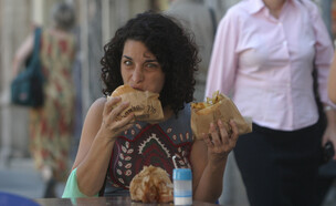 אישה אוכלת שתי מנות פלאפל (צילום: אוראל כהן, פלאש 90)