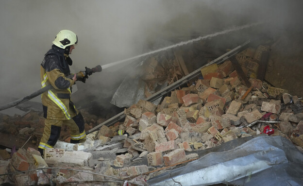 כבאי אש מכבים שרפה לאחר פגיעת מלט בבניין מגורים (צילום: AP)