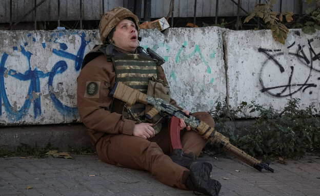 איש שירות אוקראיני תופס מחסה כאשר נשמעת צפירת תקיפ (צילום: רויטרס)