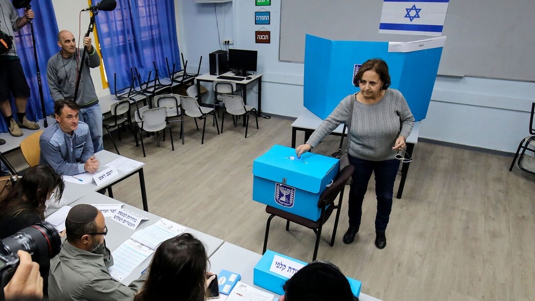 אישה מצביעה בקלפי אישה מצביעה בקלפי