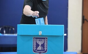 אישה מצביעה בבחירות 2021 בירושלים (צילום: EMMANUEL DUNAND, AFP via Getty Images)