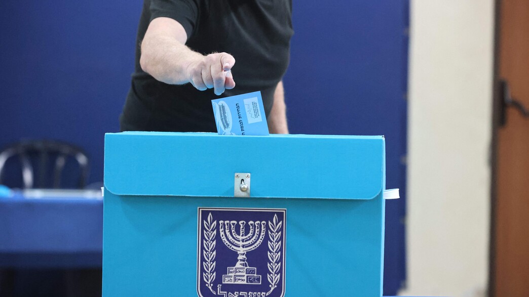 אישה מצביעה בבחירות 2021 בירושלים (צילום: EMMANUEL DUNAND, AFP via Getty Images)