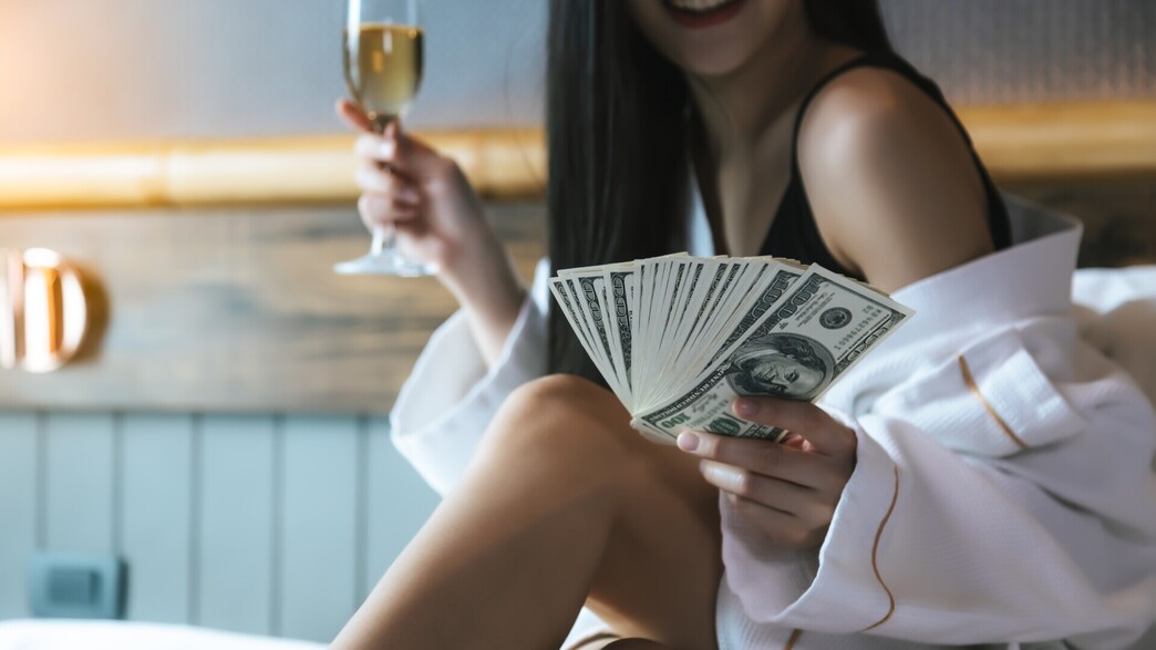 אישה עם כסף במלון (צילום: Nutlegal Photographer, shutterstock)