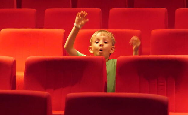 ילד יושב לבד בקולנוע (אילוסטרציה: MEDIAIMAG, shutterstock)