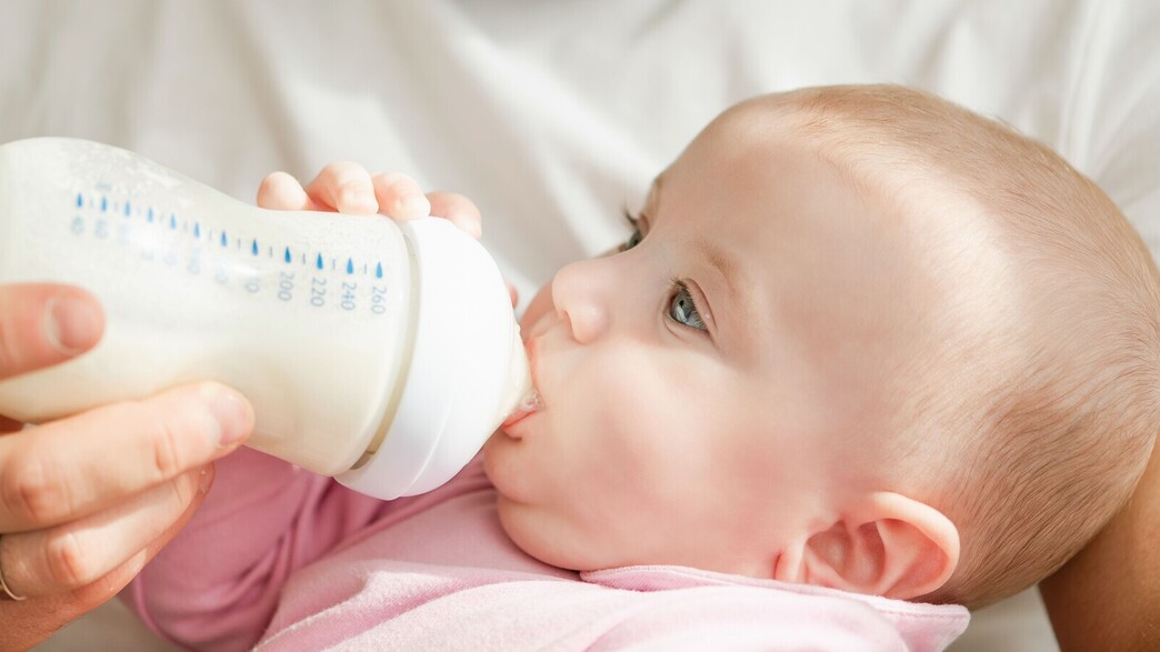 תינוק שותה מבקבוק חלב
