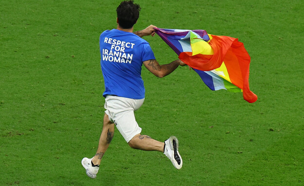 אוהד פרץ עם דגל הגאווה למשחק במונדיאל (צילום: רויטרס)