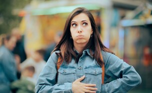 אישה רעבה מחזיקה את הבטן (צילום: Nicoleta Ionescu, shutterstock)