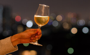 יד מחזיקה כוס יין לבן (צילום: 123RF‏)