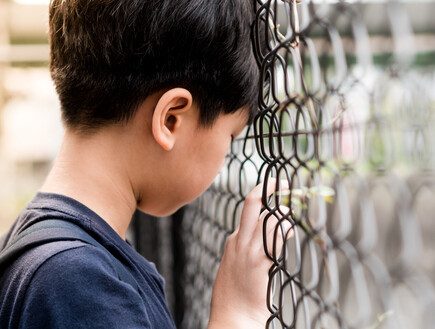 ילד משעין ראש על גדר (אילוסטרציה: myboys.me, shutterstock)