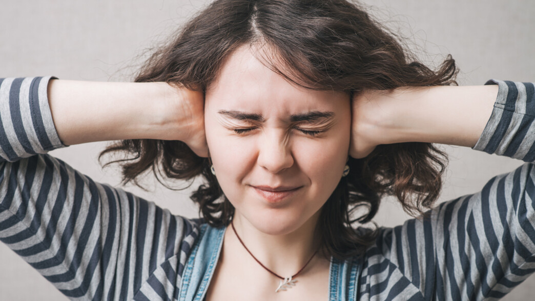 אישה מכסה אוזניים אישה מכסה אוזניים