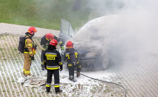 כבאים מכבים מכונית עם מנוע שרוף בוורשה (צילום: PhotoRK, shutterstock)