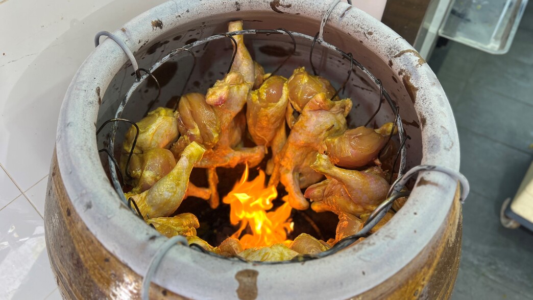 כד חרס מסורתתי ובתוכו גאי יאנג. גברת קוטייאו