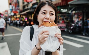 אישה אוכלת ברחוב בטייוואן (צילום: PR Image Factory, shutterstock)