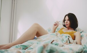 אישה מעשנת קנאביס במיטה (צילום: Elsa Donald, unsplash)