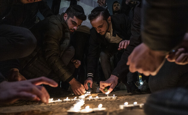 מדליקים נרות בזירת הפיגוע בנווה יעקב בירושלים (צילום: Ilia Yefimovich/picture alliance via Getty Images)