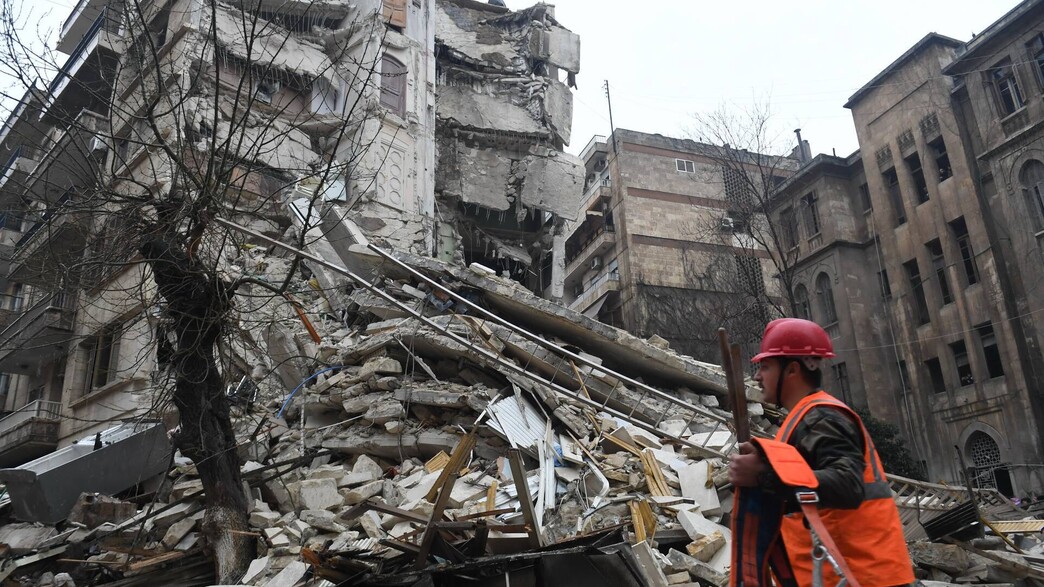 איש כוחות הצלה ליד בניין בעיר חלב שהתמוטט ברעידת האדמה  (צילום: AFP via Getty Images)