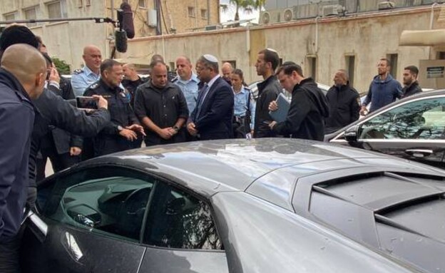 Itamar Ben Gabir et Kobi Shabtai à côté des véhicules de luxe saisis