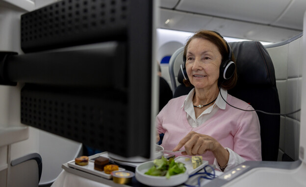 אישה אוכלת במטוס (צילום: andresr, getty images)