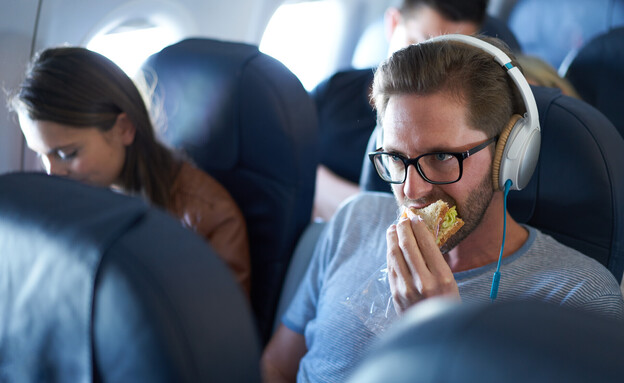 איש אוכל במטוס (צילום: amriphoto, getty images)