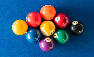 תשעה כדורי ביליארד מסודרים על שולחן (צילום: Nantapong Kittisubsiri, shutterstock)