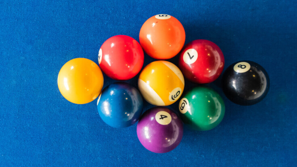 תשעה כדורי ביליארד מסודרים על שולחן