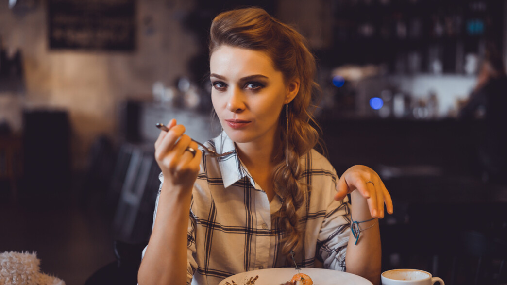 בחורה אוכלת במסעדה (צילום:  sergey causelove, shutterstock)