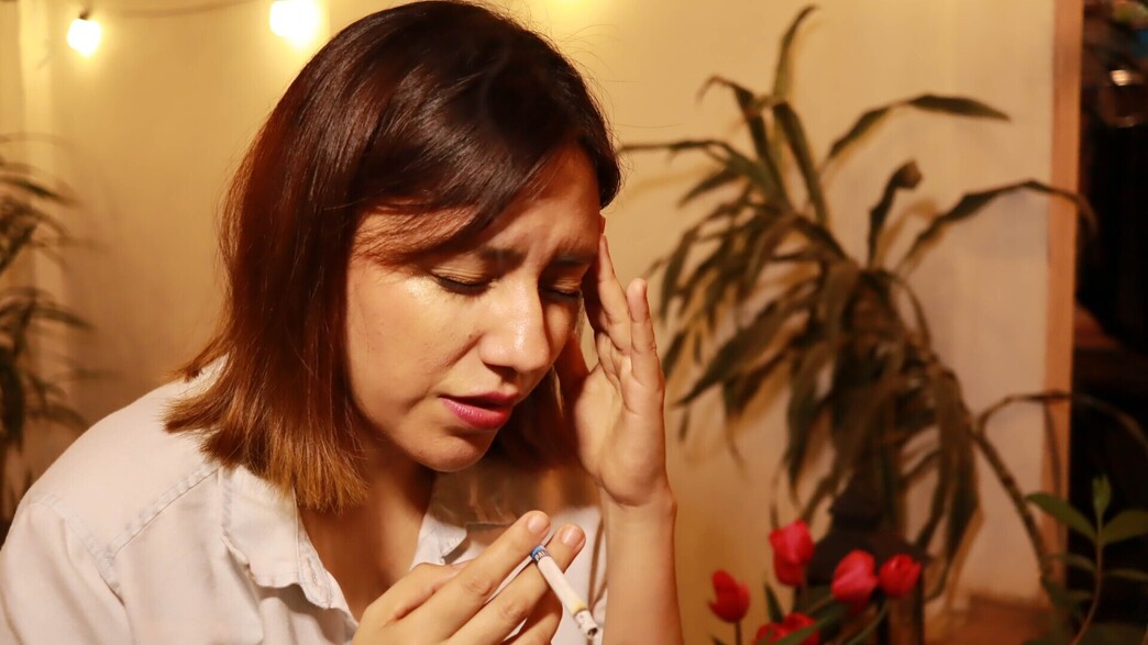אישה מעשנת סובלת מכאב ראש (צילום: Lalo Nahual, shutterstock)