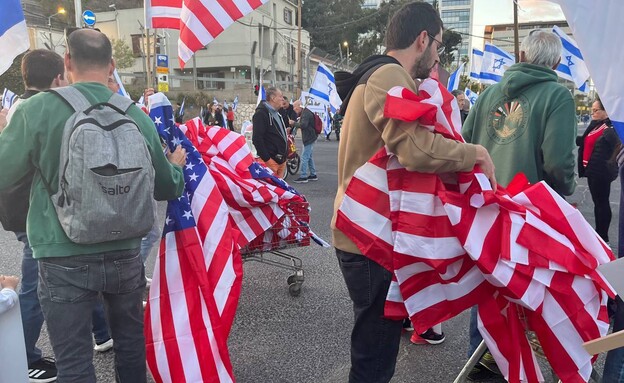לצד דגלי ישראל - מחלקים למפגינים גם דגלים של ארה"ב (צילום: n12)