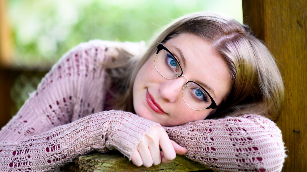 אישה צעירה עם משקפיים מסתכלת למצלמה (אילוסטרציה: Lisa5201)