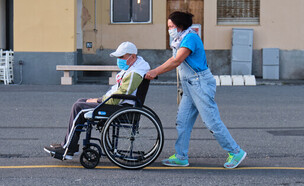 אחות מסיעה קשיש בכסא גלגלים (צילום: LS_Studio, shutterstock)