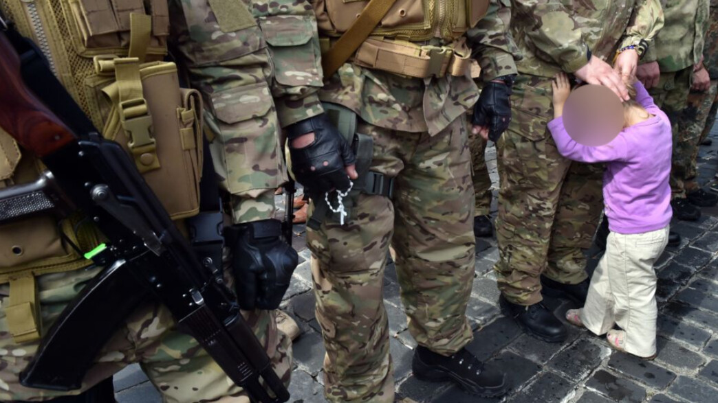 ילדה לצד חיילים אוקראינים (צילום: SERGEI SUPINSKY/AFP/GettyImages)