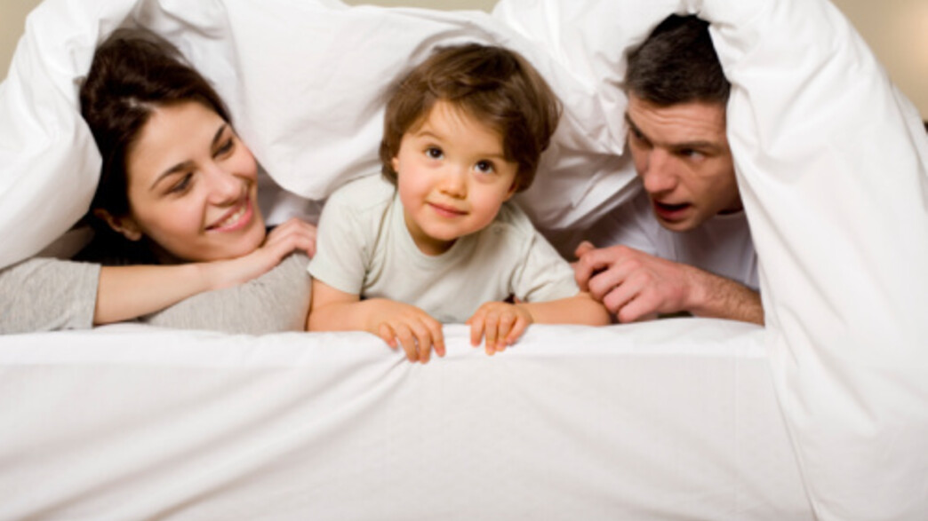 הורים וילד במיטה