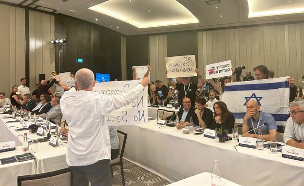 מחאה שקטה עם שלטים נגד סמוטריץ'בכנס אלי הורביץ (צילום: N12)