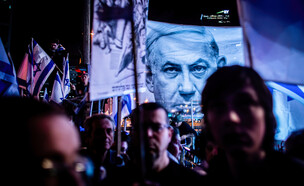 מפגינים נגד המהפכה המשפטית ומאחור תמונה של נתניהו (צילום: Eyal Warshavsky/SOPA Images/LightRocket via Getty Images)