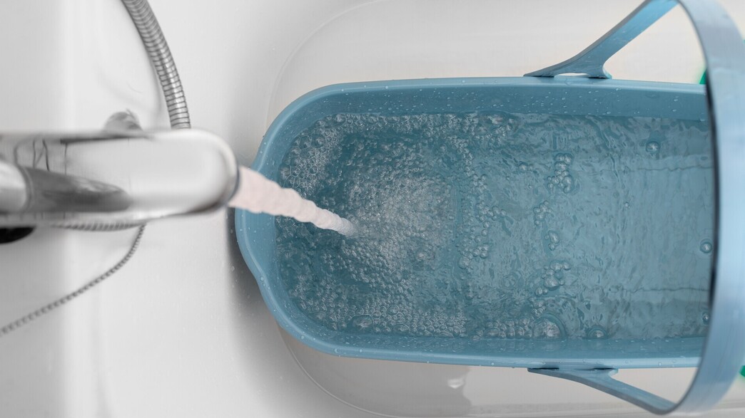 דלי מתמלא מים מהברז