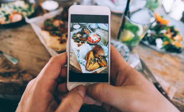 אדם מצלם את מנת האוכל שלו בסמארטפון (צילום: getty images)