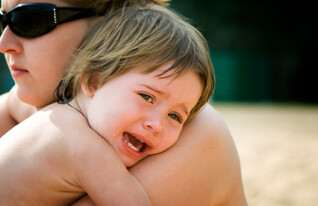 ילד בוכה ומחבק את אמו (צילום: AlexMotrenko, Istock)