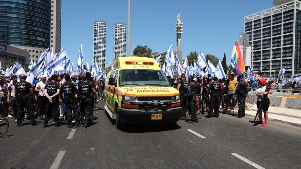 אמבולנס מנסה לעבור בין המפגינים