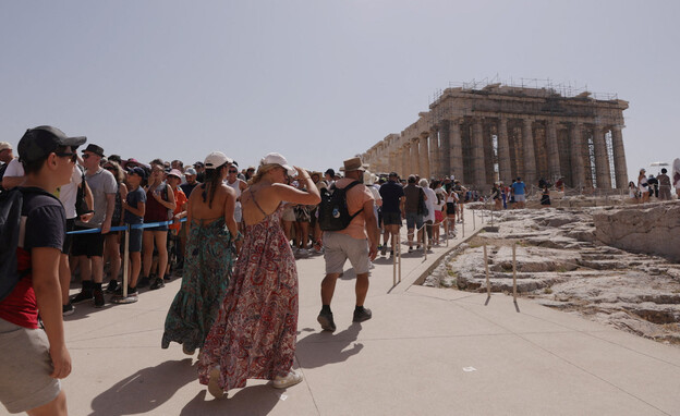 תיירים מבקרים בגבעת האקרופוליס, במהלך גל החום באתו (צילום: רויטרס)