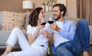 זוג שותה יין בבית (צילום: tsyhun, shutterstock)
